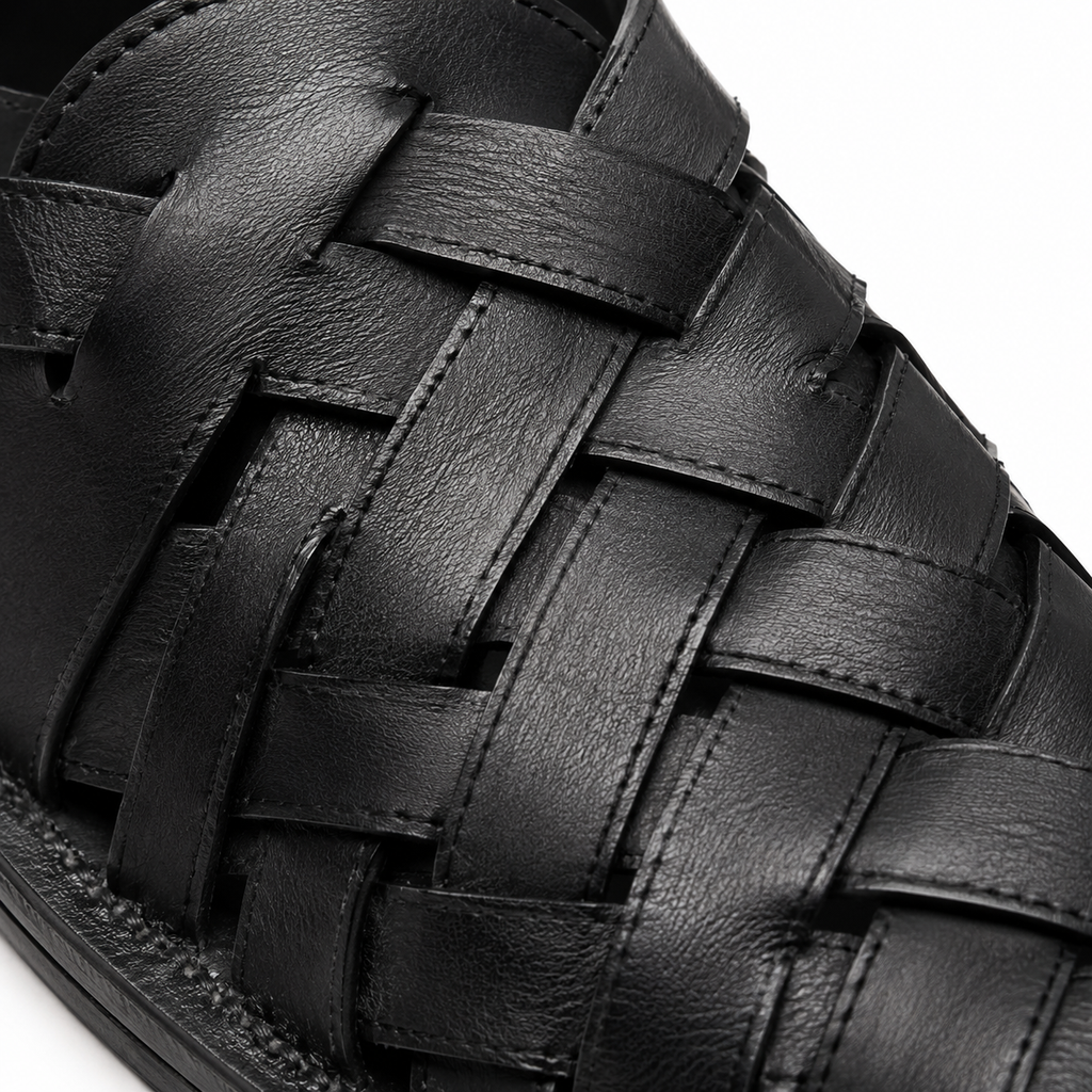 Détail du cuir tressé des sandales noires.