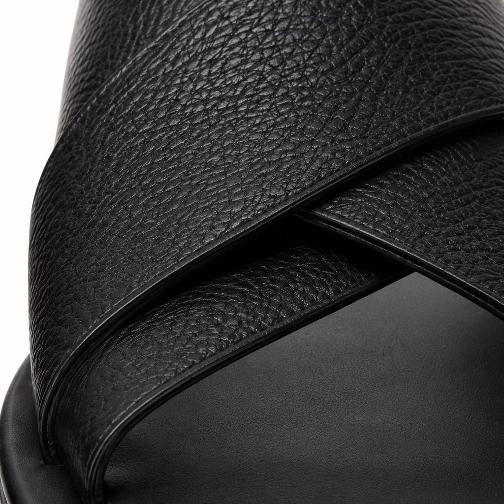 Sandales en cuir noir sur fond blanc.