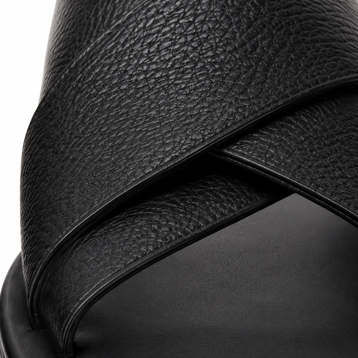 Sandales en cuir noir sur fond blanc.