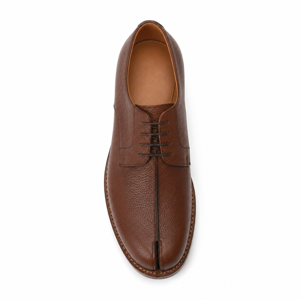 Détail du cuir grainé de la chaussure Derby marron